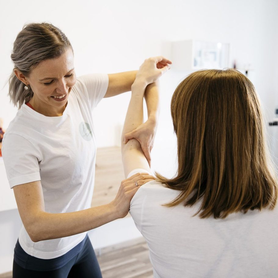 Zwei Läufer in sportlicher Kleidung laufen auf einer roten Rennbahn.
