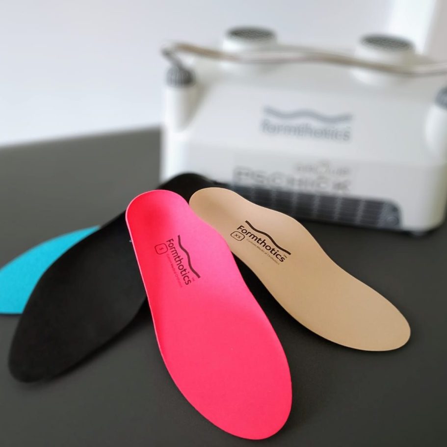 Zwei Läufer in sportlicher Kleidung laufen auf einer roten Rennbahn.